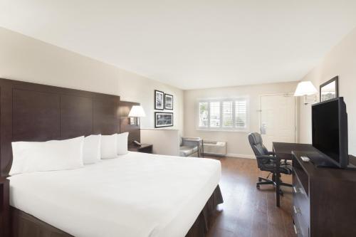 莫德斯托萨利达/莫德斯托速8酒店的酒店客房设有一张白色大床和一张书桌