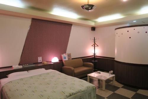 Miyaki嘉年华情趣酒店的一间医院间,配有一张床和一把椅子