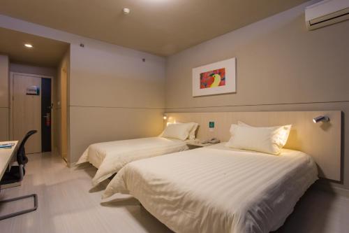 宝鸡锦江之星宝鸡高铁站酒店的配有白色床单的酒店客房内的两张床