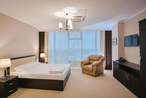 沃罗涅什Zastava Hotel的配有一张床和一把椅子的酒店客房