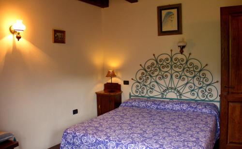 Vezzi PortioLe Petit Chateau的一间卧室配有一张带紫色棉被的床
