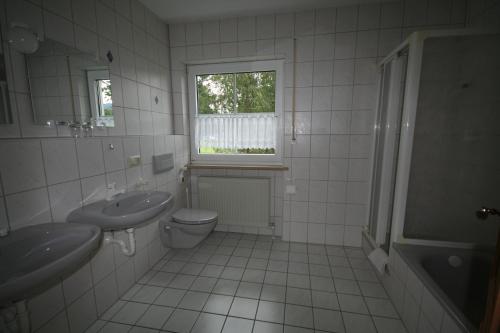 瓦门施泰纳赫Haus Cäcilia的一间带水槽和卫生间的浴室以及窗户。