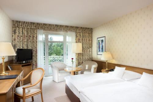 巴特维尔东根玛丽蒂姆巴特维尔东根酒店的酒店客房配有一张床、一张书桌和一台电视。