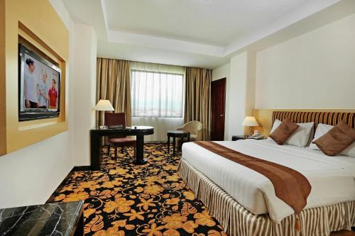 巴东巴东洛基广场酒店的配有一张床和一张书桌的酒店客房