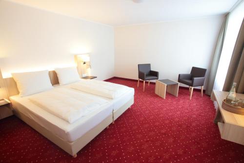 新维德小酒馆城堡酒店的酒店客房带白色的床和两把椅子