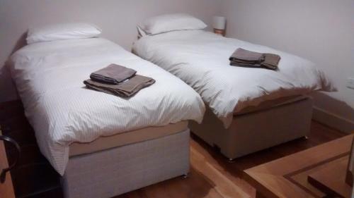 兰戈伦Jasmine Cottage的卧室内的两张床和毛巾