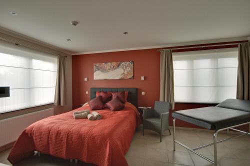宗奥芬B&B Noord-Zuid的一间卧室配有红色的床和椅子