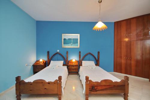 古厄庇道鲁斯Hotel Marialena的蓝色墙壁客房的两张床