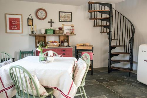 奇平卡姆登The Annexe的一间带桌子和螺旋楼梯的用餐室
