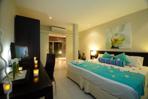 格兰贝伊Ocean Villas Hotel的一间卧室配有一张床、一张书桌和一台电视