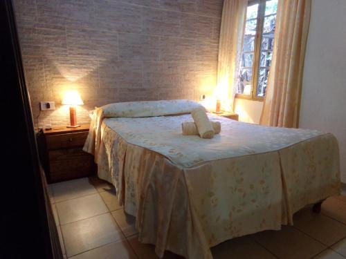 门多萨Cabañas El Challao的一间卧室配有一张带两盏灯的床和一扇窗户。