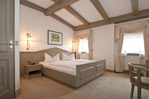 霍亨斯泰因-埃尔恩斯塔尔Hotel DREI SCHWANEN - Ristorante Due Fratelli的一间卧室设有一张大床和两个窗户。