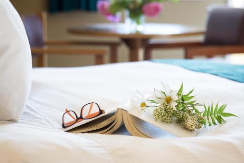 纳卡斯普The Lodge at Arrow Lakes的床上一副眼镜和一本书