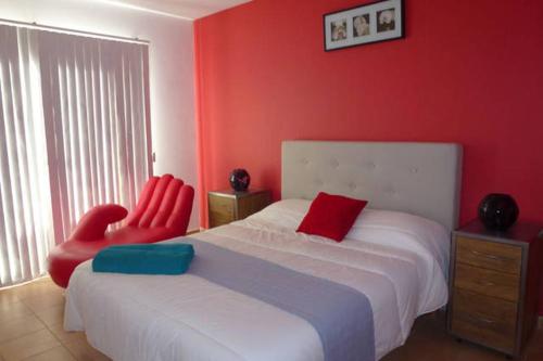 蓬塔普里马Villa Son Remei的一间卧室配有两张红色椅子和一张床