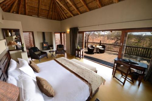 马迪克韦狩猎保护区Etali Safari Lodge的一间带大床的卧室和一个阳台
