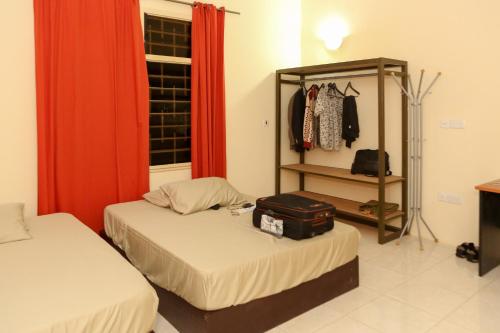 阿克拉Connect Africa Apartments的一间设有两张床的房间和一个带行李箱的架子