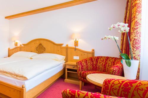 采尔马特艾克塞西尔酒店的配有一张床和一把椅子的酒店客房