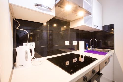 萨格勒布Apartman Vita的厨房配有白色橱柜和水槽