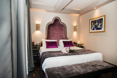 罗马罗马HT6酒店的酒店客房设有一张大床和紫色床头板