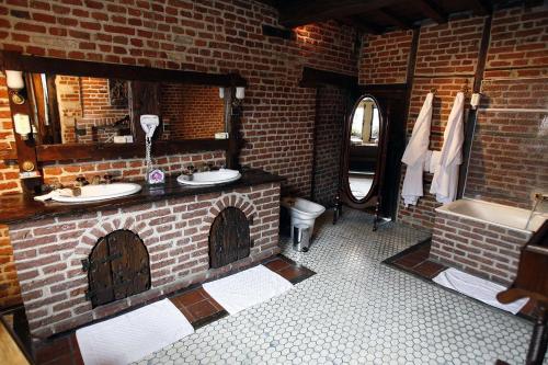 瓦朗西纳好农夫客栈的砖砌浴室设有2个水槽和1个浴缸