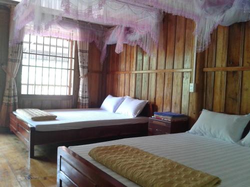 Ba Be18Hoàng Nguyên Homestay Ba Be的一间卧室配有两张床和粉红色窗帘