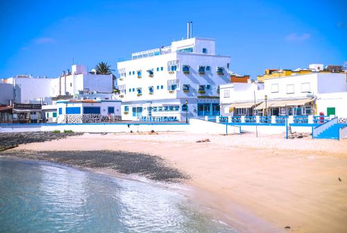 科拉雷侯AVANTI Lifestyle Hotel - Only Adults的白色建筑和水面的海滩