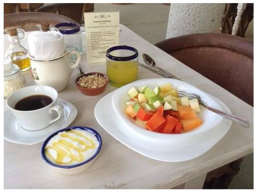 兹波利特HEVEN Residence的一张桌子,上面放着一盘水果和一杯咖啡