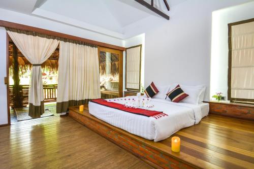 毛淡棉嘉玛德维皇后酒店的一间卧室,卧室内配有一张大床