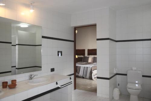 圣洛伦索B&B Casa Hernández的一间带水槽和卫生间的浴室以及一间卧室