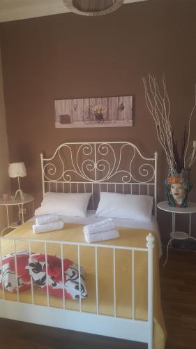 卡塔尼亚Sicily Home Center的一间卧室,配有一张带床头板和花瓶的床