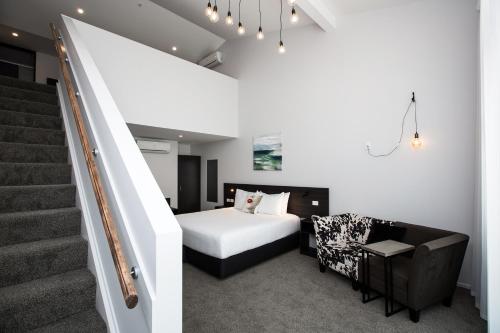 新普利茅斯梅特洛特汽车旅馆的一间卧室设有一张床和一个楼梯