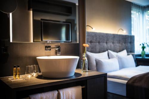 美因河畔法兰克福法兰克福萨克斯城市设计酒店的酒店客房设有水槽和一张床