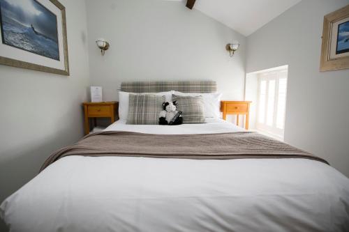 查尔芬特－圣贾尔斯常春藤宾馆的一张白色的床,上面有泰迪熊