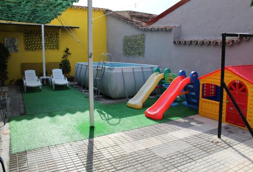 梅里达Imperial Mérida的后院设有带滑梯和游泳池的游乐场