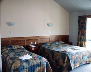 半月湾南海汽车旅馆 - 斯图尔特岛的酒店客房设有两张床和窗户。