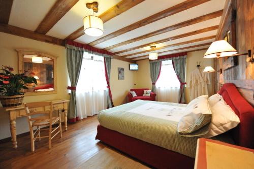 DouesAffittacamere Le Relais De La Grandze的卧室配有一张床和一张桌子及椅子
