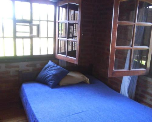 帕特拉德拉帕特拉Angeluz Paso De La Patria的一间卧室配有蓝色的床和2个窗户