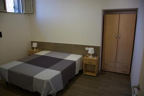 维耶斯泰Appartamenti Posta del Sole的一间带床和橱柜的小卧室