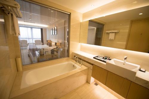苏州苏州太阳广场酒店的带浴缸、水槽和镜子的浴室