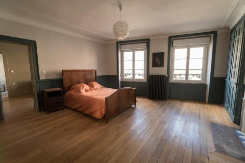 米尔库尔Les Gites Historiques的卧室配有一张床、木地板和窗户。