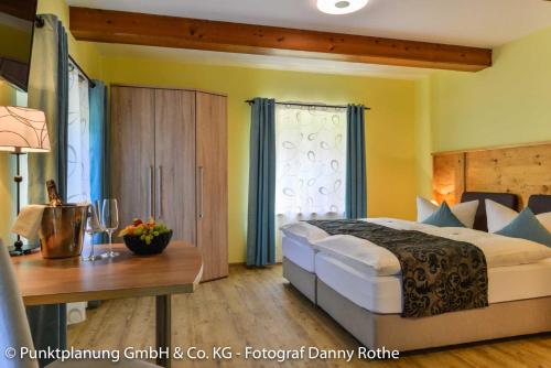 Obing奥贝维特酒店的一间卧室配有一张大床和一张木桌