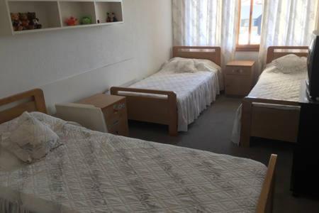 FayţrūnSpacious chalet in Satellity - Faitroun的酒店客房设有两张床和窗户。