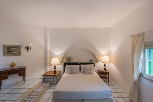 莫诺波利马塞里亚伊尔梅洛格拉诺酒店的一间卧室配有一张床、两盏灯和一个窗户。