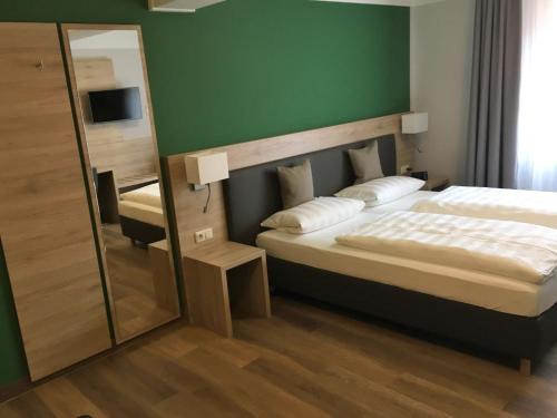 慕尼黑Eberl Hotel Pension München Feldmoching的一间卧室配有一张大床和镜子