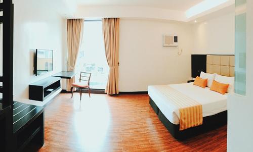 武端市欧厄齐斯酒店的配有一张床和一张书桌的酒店客房