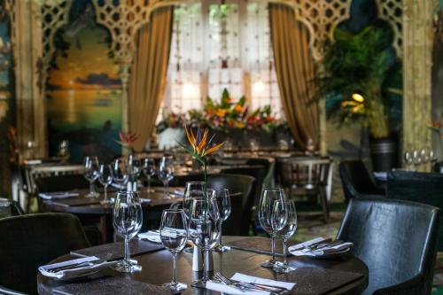 海斯Port Lympne Mansion Hotel的餐厅设有桌子和酒杯