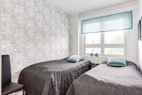 奥卢Apartment Pohjanpoika的一间卧室设有两张床和窗户。