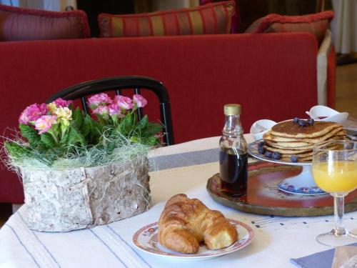 富瓦La Mirandole的一张桌子,上面放着一盘羊角面包和一瓶苏打水