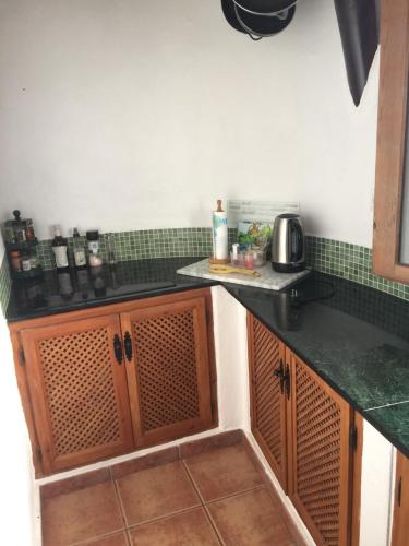 GaleraCueva Chelaja的厨房配有黑色台面和绿色瓷砖