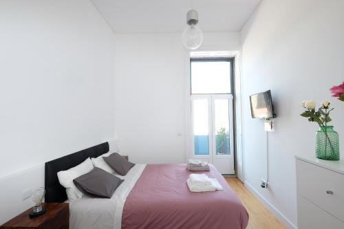 波尔图波尔图公爵公寓的白色的卧室设有一张大床和一个窗户